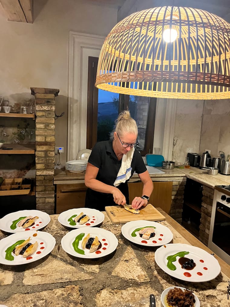 Celine plating chicken dishes with colorful sauces