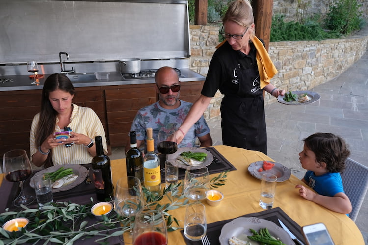 Chef Celine serving dinner to a family at their villa